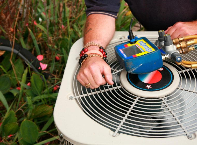 worker giving maintenance to an hvac box on the grass